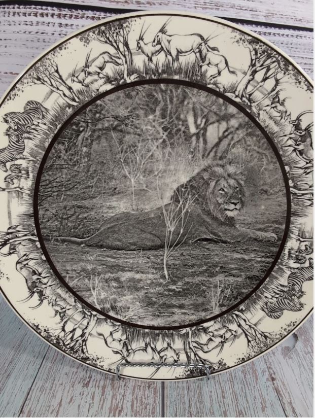 Angled upright view showing the glazed ceramic surface and wildlife border