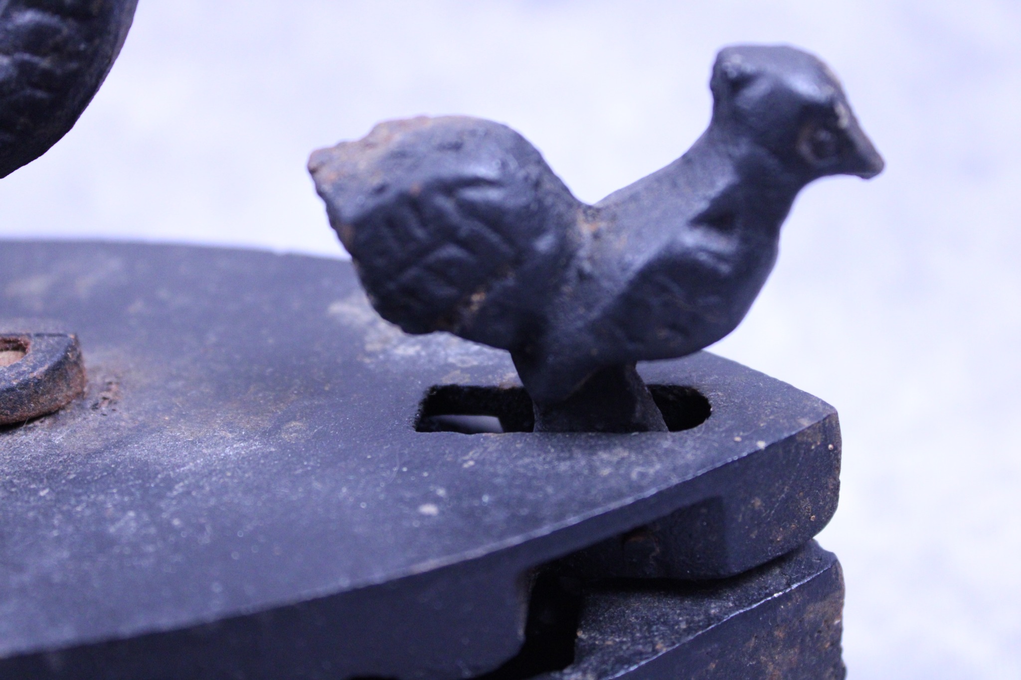 Figural rooster catch on the vintage cast iron charcoal box iron
